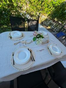 a table with plates and utensils on it at Luka Vacation House in Ulcinj
