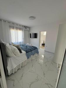 a bedroom with a bed with marble floors and a mirror at Luka Vacation House in Ulcinj