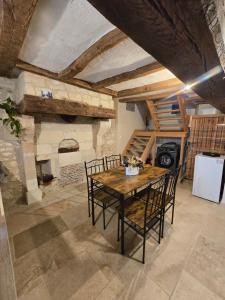 a dining room with a table and chairs and a fireplace at L'Authentique in Mouzay