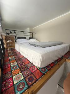 a bedroom with a bed on a colorful rug at Sweet in Nahariyya