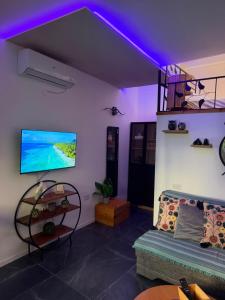 a room with a bed and a tv on a wall at Sweet in Nahariyya