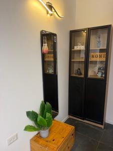 a room with a black cabinet and a table with a plant at Sweet in Nahariyya +6 photos