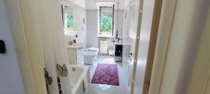 a white bathroom with a sink and a toilet at Private Space near City Center in Genoa