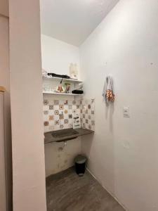 a room with a white wall and a shelf at Loft Moderno in Mossoró