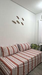 a room with a bed with a red and white striped blanket at Loft Moderno in Mossoró