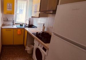 a kitchen with a stove and a white refrigerator at Private Space near City Center in Genoa