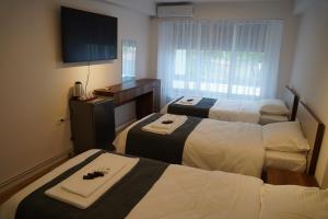 a hotel room with two beds and a television at Parkside Boutique Hotel in Prishtinë