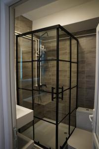 a glass shower in a bathroom with a person taking a picture at Parkside Boutique Hotel in Prishtinë +60 photos