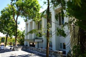a building with trees in front of it at Parkside Boutique Hotel in Prishtinë