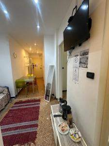a room with a tv on the wall and a table at Private Space near City Center in Genoa