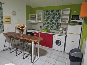 a kitchen with a table and a washing machine at BungalowFlo - Maison de vacances avec Spa in Petit-Canal