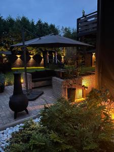 a patio with an umbrella and a fire place at Apartament Morgan in Mieroszyno