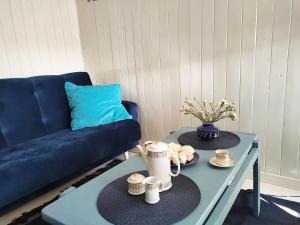 a living room with a blue couch and a coffee table at Modry Domek Szczyrk domek na wyłączność z kominkiem in Szczyrk