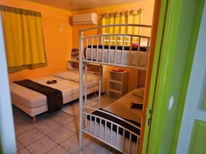 a room with two bunk beds and a room with a bed at BungalowFlo - Maison de vacances avec Spa in Petit-Canal