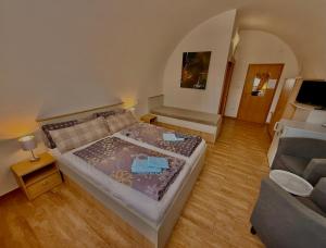 a small bedroom with a bed and a couch at Penzion u Pidly in Mariánské Lázně
