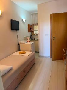 a small bedroom with a bed and a kitchen at Apartman Luka Pogled na more in Neum