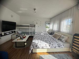 a bedroom with a bed and a desk and a television at Apartment On the way in Stolac