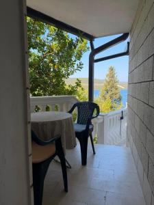 a table and chairs on a balcony with a view of the ocean at Apartman Luka Pogled na more in Neum