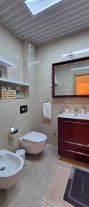 a bathroom with a sink and a toilet and a mirror at Azure Horizon Pržno in Sveti Stefan