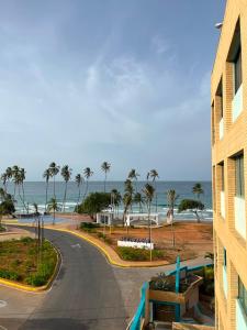 a road leading to the beach with palm trees and a building at Residencia manatial in La Mira