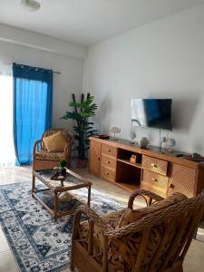 a living room with a tv and a couch and chairs at Residencia manatial in La Mira