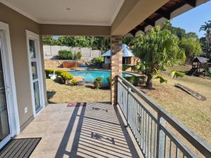 a porch with a view of a swimming pool at Nombelas Cottage in Westville