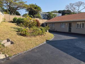 a house with a driveway in front of a yard at Nombelas Cottage in Westville