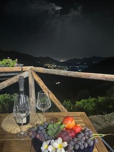 a table with two glasses of wine and a plate of fruit at Villa Luca e Vale in Graniti