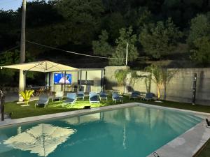a swimming pool in a backyard with chairs and a screen at Villa Luca e Vale in Graniti