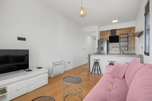 a living room with a pink couch and a kitchen at Azure Bay Apartments in Donja Lastva +28 photos