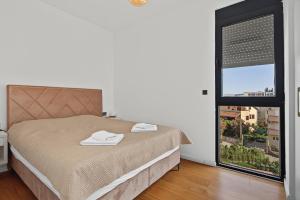a bedroom with a bed and a large window at Azure Bay Apartments in Donja Lastva