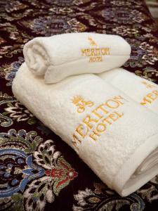 two white towels with the words vacation not a guest house at Meriton Hotel Bukhara in Bukhara
