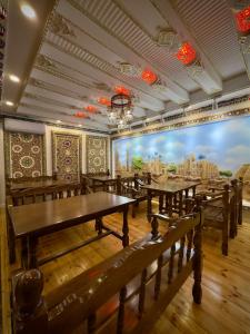 a row of tables in a restaurant with a mural at Meriton Hotel Bukhara in Bukhara +59 photos