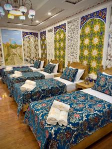 a group of beds in a room with colorful walls at Meriton Hotel Bukhara in Bukhara
