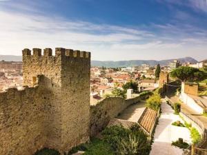 an old stone wall with a city in the background at Domo via Ozieri in Iglesias +12 photos