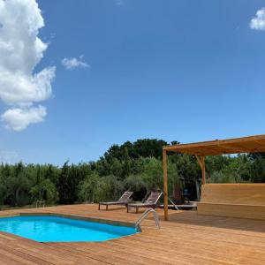 a deck with two chairs and a swimming pool at Casale Scirbia in Marzamemi
