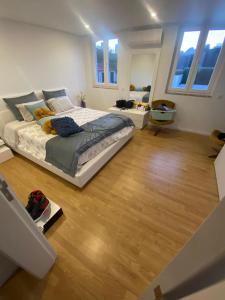 a bedroom with a large bed and wooden floors at Casa dos Paralelos RC in Moledo +3 photos