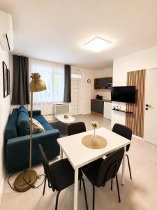 a living room with a blue couch and a table at Barcs Thermal Apartments in Barcs