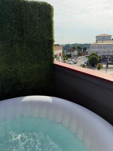 a hot tub on a balcony with a green hedge at Cartagena Urban Escape in Brčko