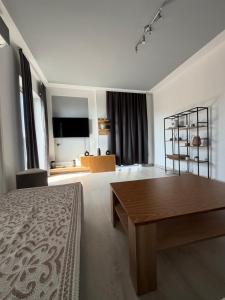 a bedroom with a bed and a table and a television at Cartagena Urban Escape in Brčko