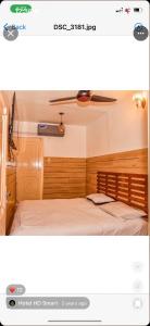 a bedroom with a bed with a wooden headboard at HD Smart Hotel in Kot Mergulla