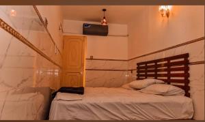 a bedroom with a bed and a tv on the wall at HD Smart Hotel in Kot Mergulla