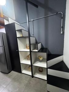 a black and white staircase in a room with a refrigerator at Village Conti Ideal para casal com Ar C01 in Campinas