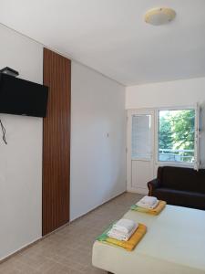 a living room with a couch and a television at vila Rosmarin in Dobra Voda