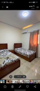 two beds are in a room with a window at Ghazala resort in Marsa Matruh
