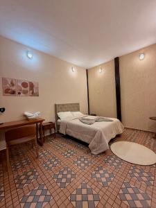 a bedroom with a bed and a desk in a room at Pousada Nhá Luz in Salesópolis +19 photos