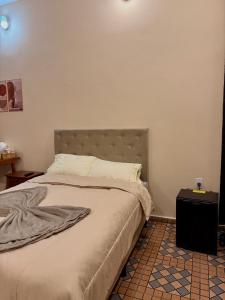 a bedroom with a large bed with a headboard at Pousada Nhá Luz in Salesópolis