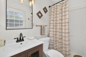 a bathroom with a toilet sink and a shower curtain at Muirs Chapel Retreat in Greensboro +34 photos