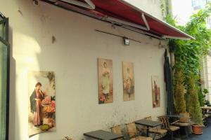 a wall with paintings on it with tables and chairs at Roza Taksim in Istanbul