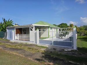 a white house with a gate and a fence at BungalowFlo - Maison de vacances avec Spa in Petit-Canal